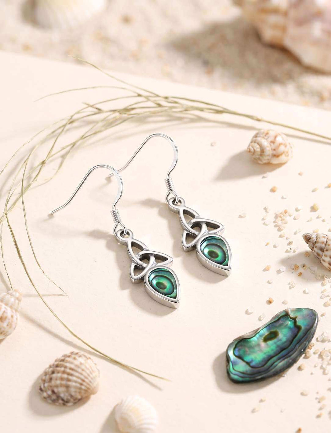 Triquetra Ohrhänger Silber mit Perlmutt zwischen Muscheln und Sand