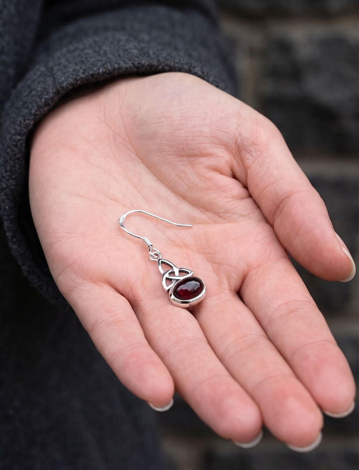Granat Ohrhänger mit Triquetra in einer Handfläche als Größenvergleich