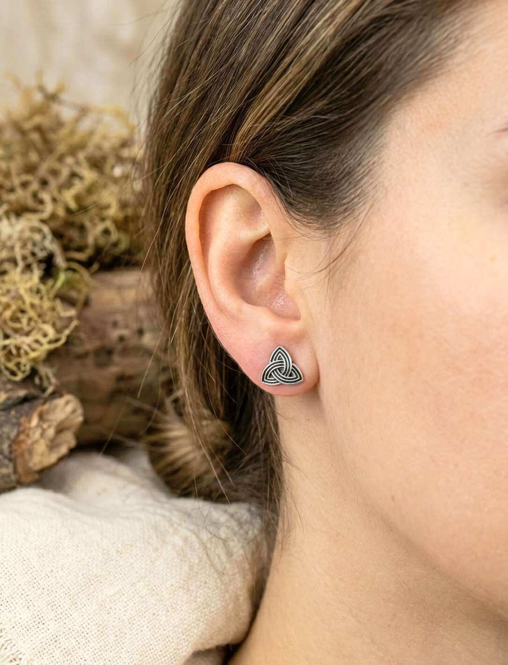 Frau trägt Triquetra Ohrstecker aus Silber Nahaufnahme am Ohr