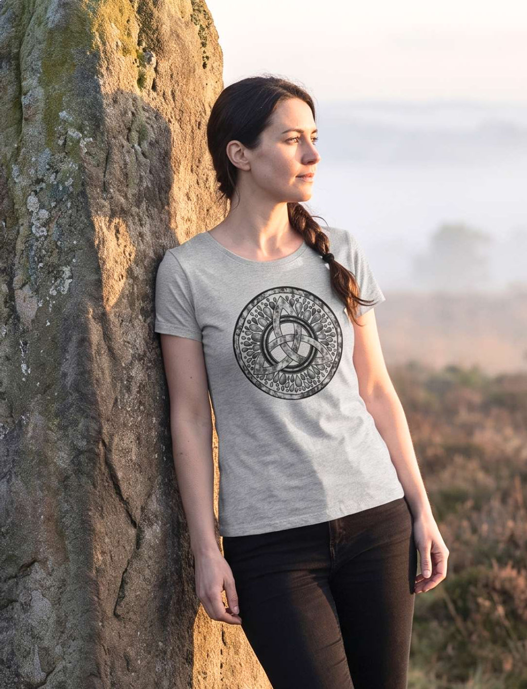 Frau im graumelierten Damen Shirt mit Triquetra an einem Menhir in nebliger Heide