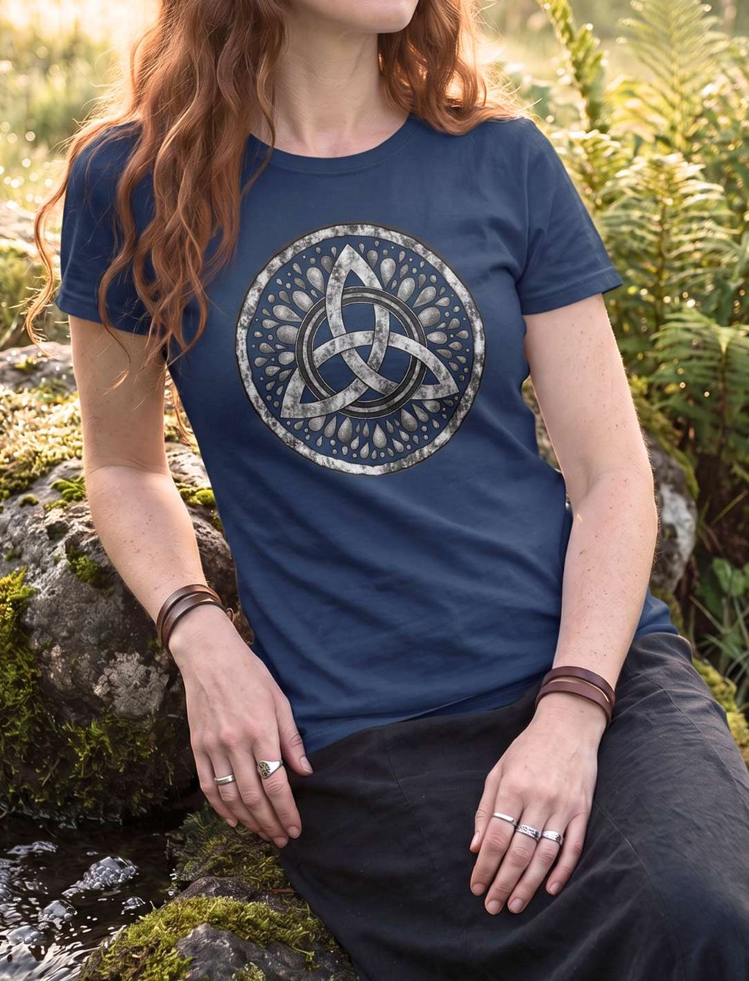 Navyblaues Damen T-Shirt mit keltischem Knotenmotiv, Trägerin sitzt auf einem bemoosten Felsen