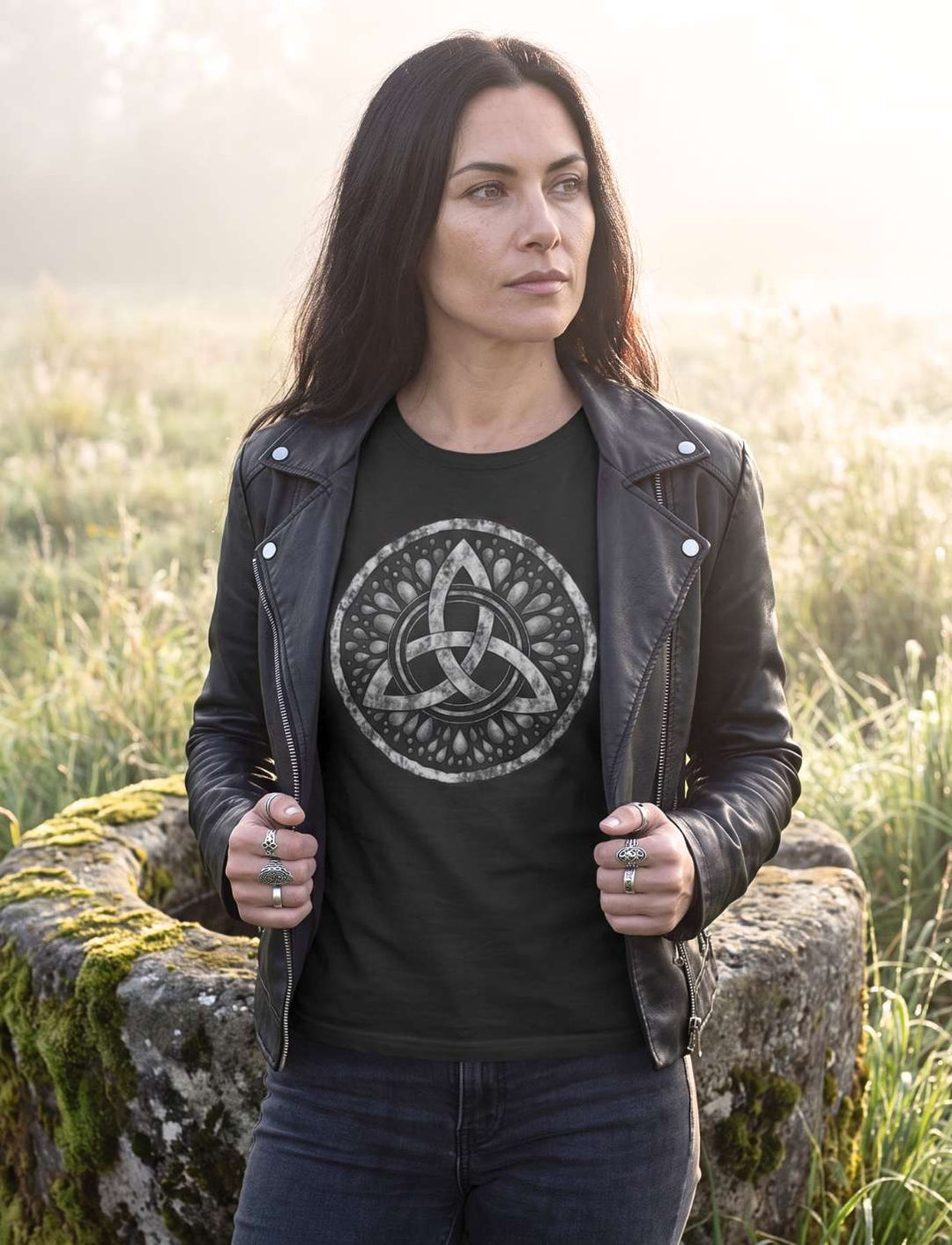 Schwarzes Damen Shirt mit Triquetra unter offener Lederjacke, Morgenlicht an einer Quelle