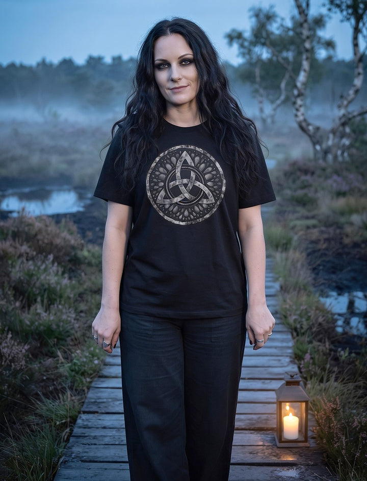 Triquetra – Sichel der Seherin: Frau im schwarzen Damen Shirt in lässiger Passform auf einem Bohlenweg im nebligen Moor