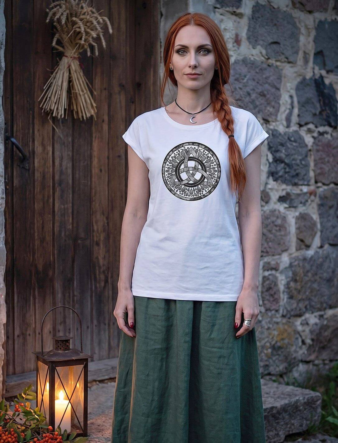 Weißes Damen Longshirt mit keltischer Triquetra, rothaarige Frau vor alter Holztür mit Laterne und Vogelbeeren