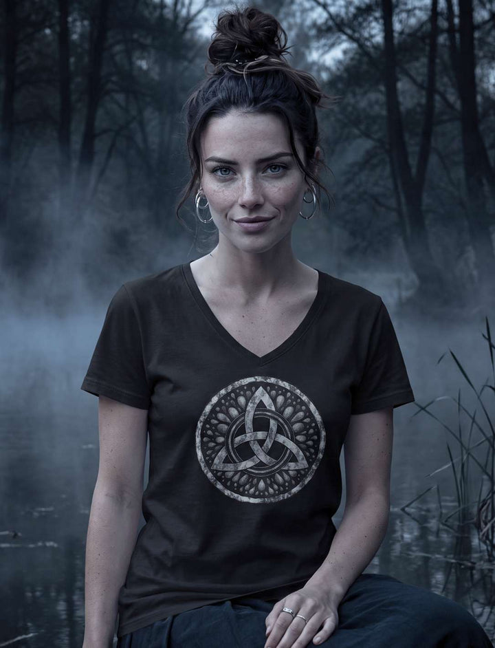 Frau sitzt im schwarzen V-Neck Shirt mit keltischem Knoten am Ufer eines Weihers im Nebel