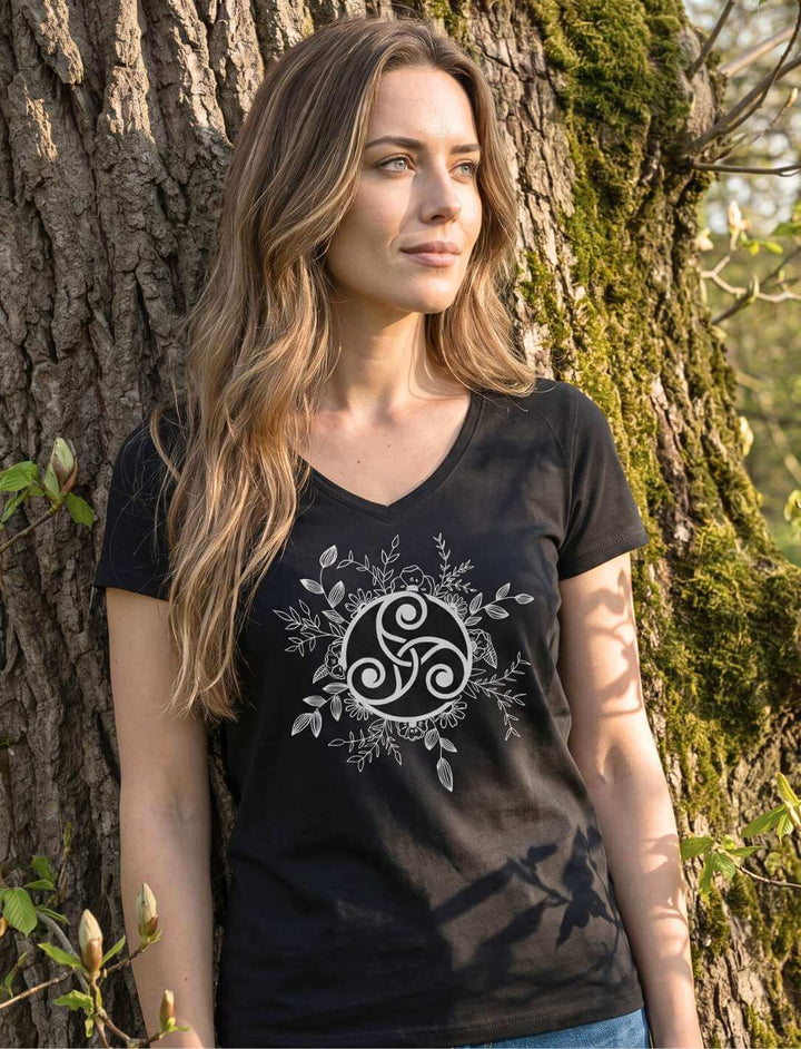 Triskele der ewigen Wandlung - Keltisches Damen V-Neck Shirt in Schwarz, getragen an einem alten moosbewachsenen Baumstamm