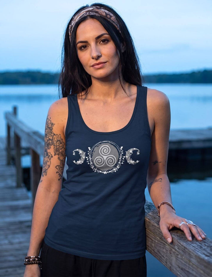 Frau am Holzsteg in der blauen Stunde trägt Tank Top in Navy mit Triskele-Motiv