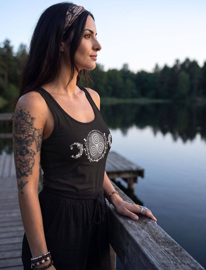 Frau am See in der Dämmerung trägt ärmelloses Tank Top in Schwarz mit keltischem Mondmotiv