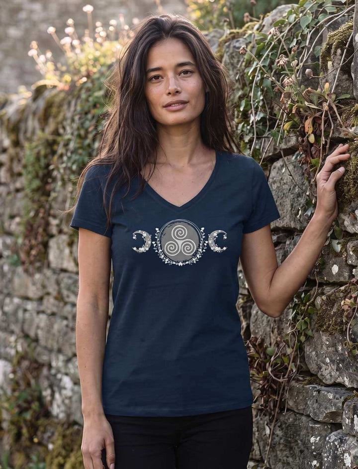 Frau in navyblauem V-Neck Shirt an einer alten Steinmauer mit Efeu in der Dämmerung
