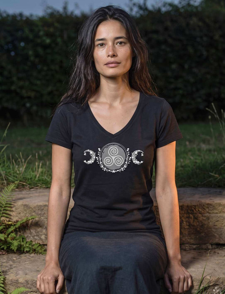 Frau sitzt in schwarzem V-Neck Shirt auf einer Steinstufe im dunklen Garten unter dem Mond