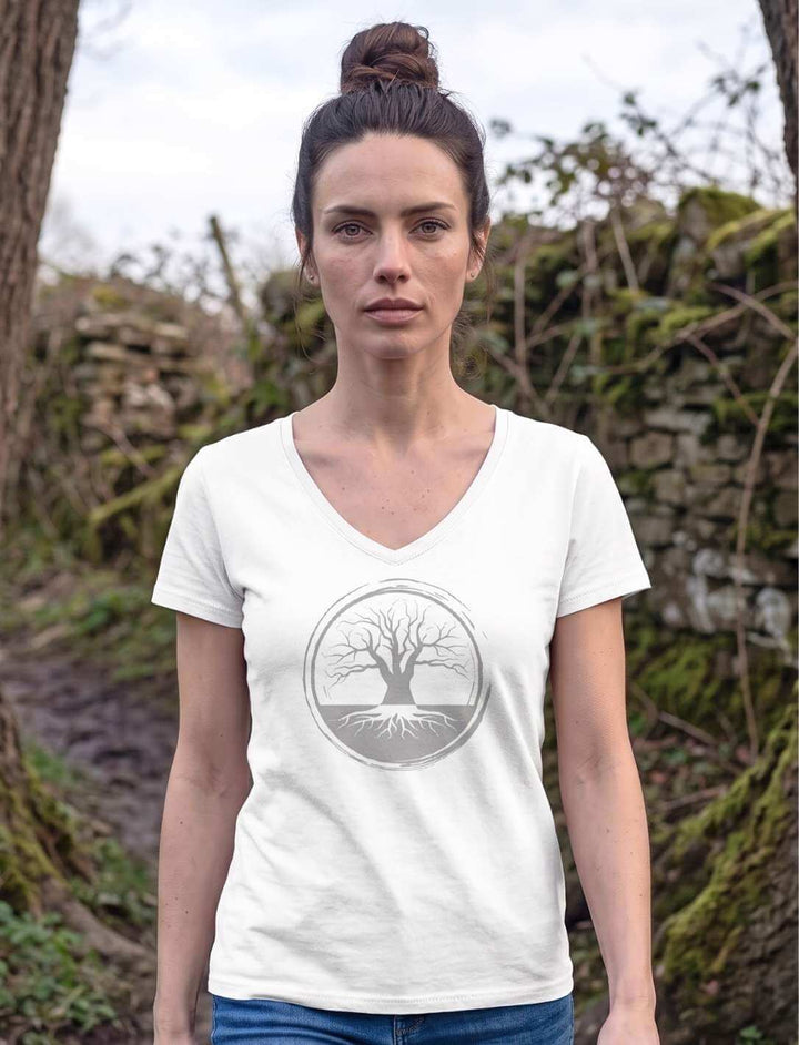 Frau in weissem V-Neck Shirt auf einem Waldpfad an einer alten Trockenmauer
