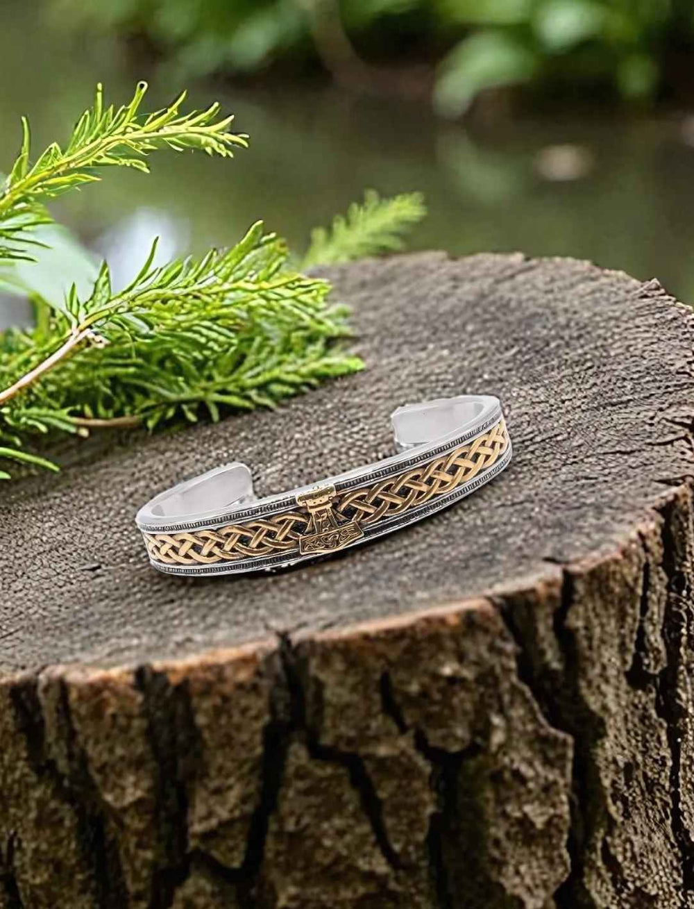Goldener Wikinger Armreif aus Edelstahl mit Mjölnir Design auf Baumstumpf
