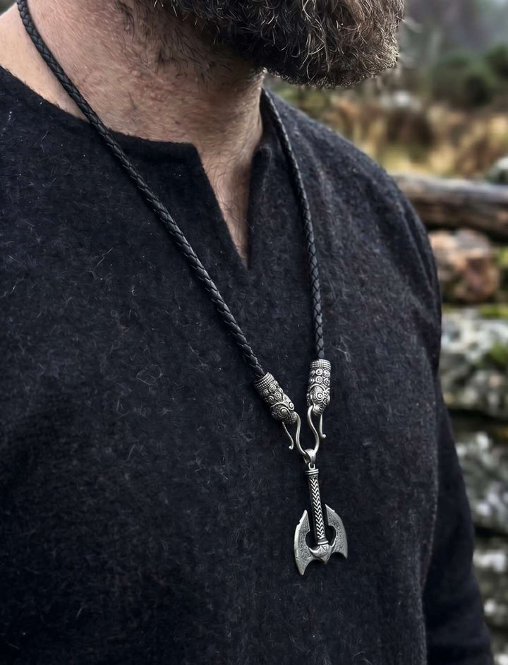 Mann trägt Wikinger Doppelaxt Anhänger an schwarzem Lederband zu dunklem Shirt
