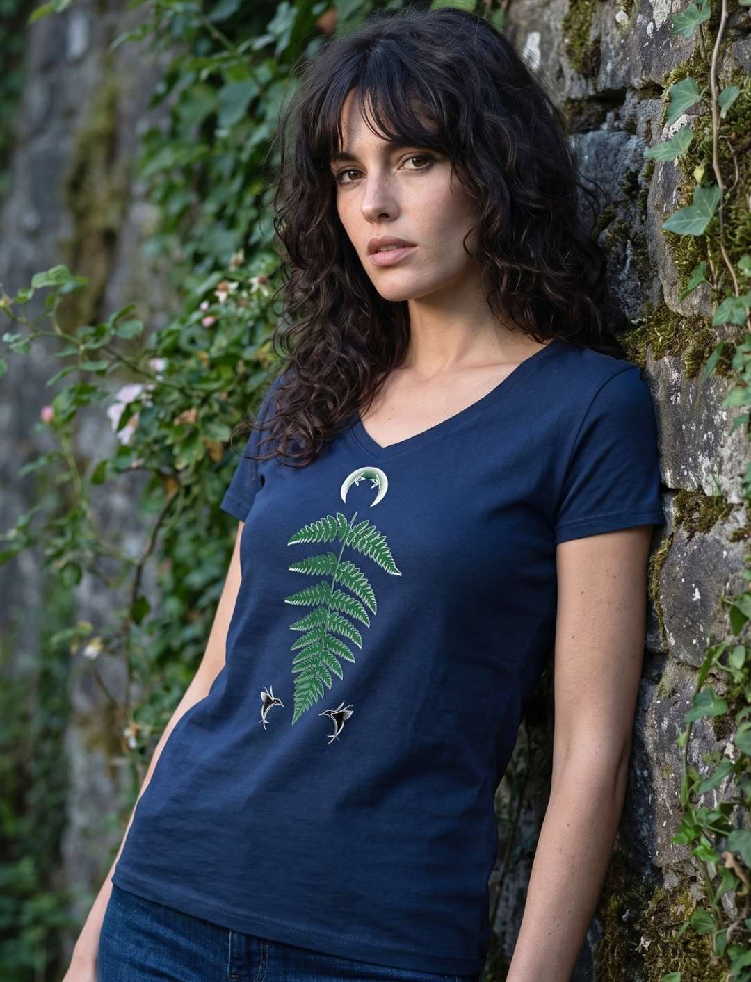 Navyblaues Damen V-Neck Shirt mit Farnmotiv, Frau lehnt an einer efeubewachsenen Steinmauer
